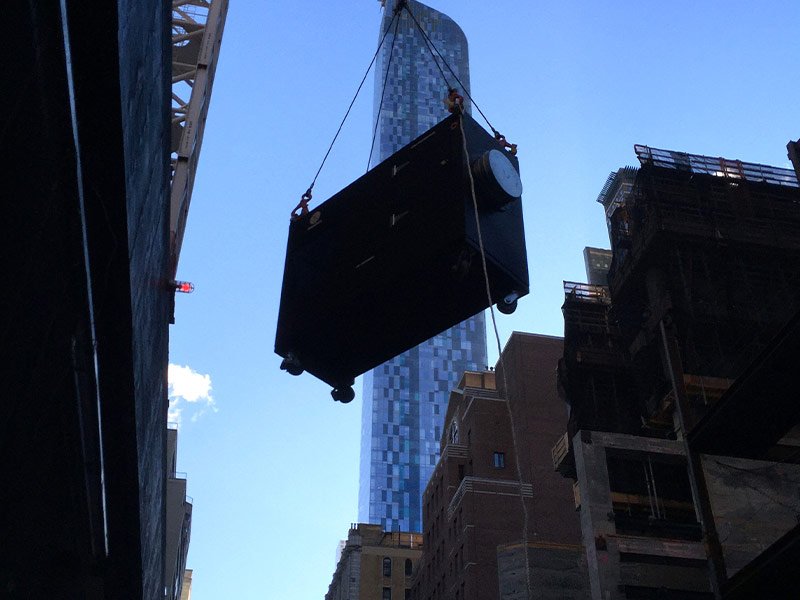 Crane lifting rented heater on New York Construction site